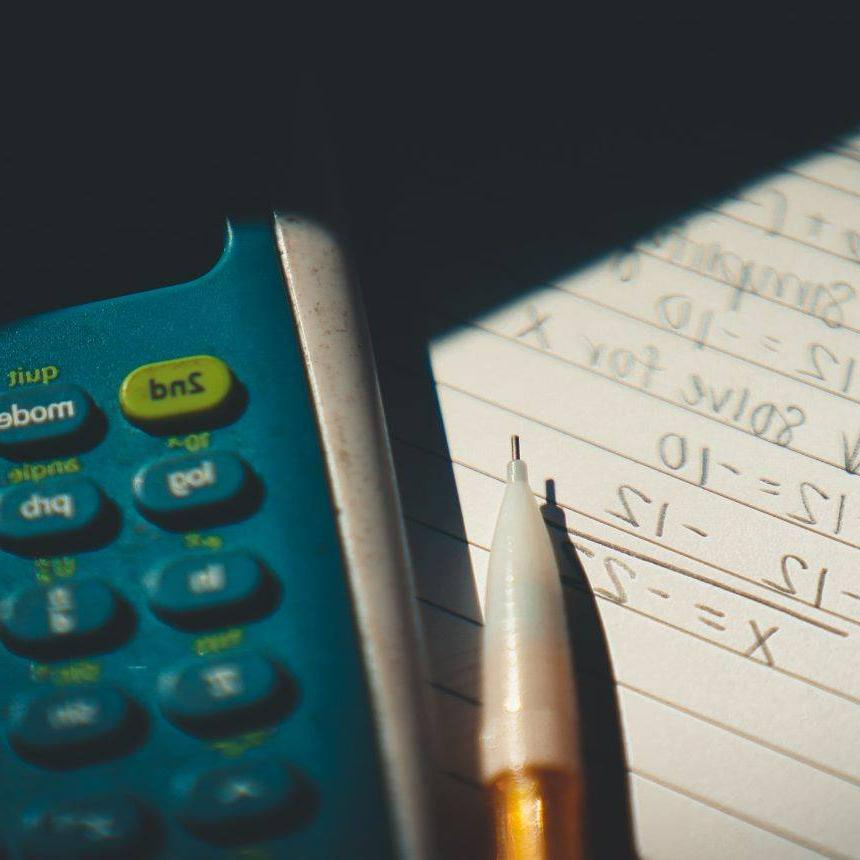 A calculator and pencil laying on a piece of paper